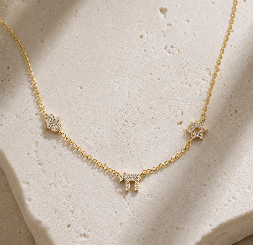 Gold tone 3 Pavé Charm Choker Necklace styled on a neutral stone surface.