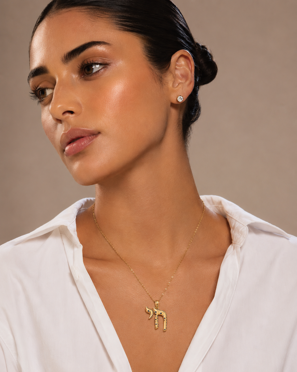 Model wearing the gold tone TLV Chai Necklace.