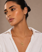 Model wearing the gold tone TLV Chai Necklace.