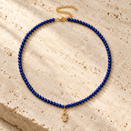 Adele Hamsa Beaded Necklace in Lapis on textured stone.