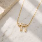 Gold tone Baguette Chai Necklace styled on a neutral stone surface.