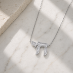 Silver tone Baguette Chai Necklace styled on a neutral stone surface.