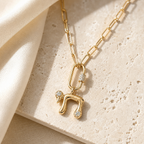 Gold tone Bubble Chai Lariat Necklace styled on a neutral stone surface.