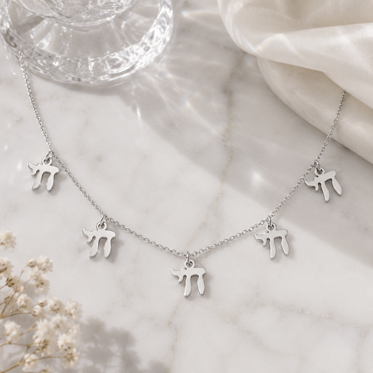 Silver tone “Chai on Life” Choker Necklace styled on a neutral stone surface.