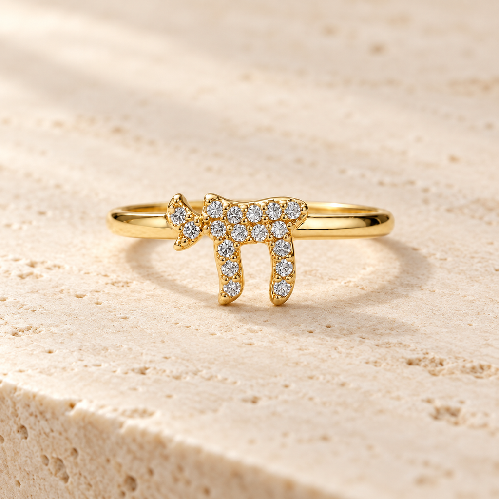 Gold tone Chai Pavé Ring on neutral stone surface