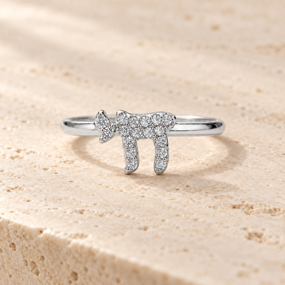 Silver tone Chai Pavé Ring on neutral stone surface