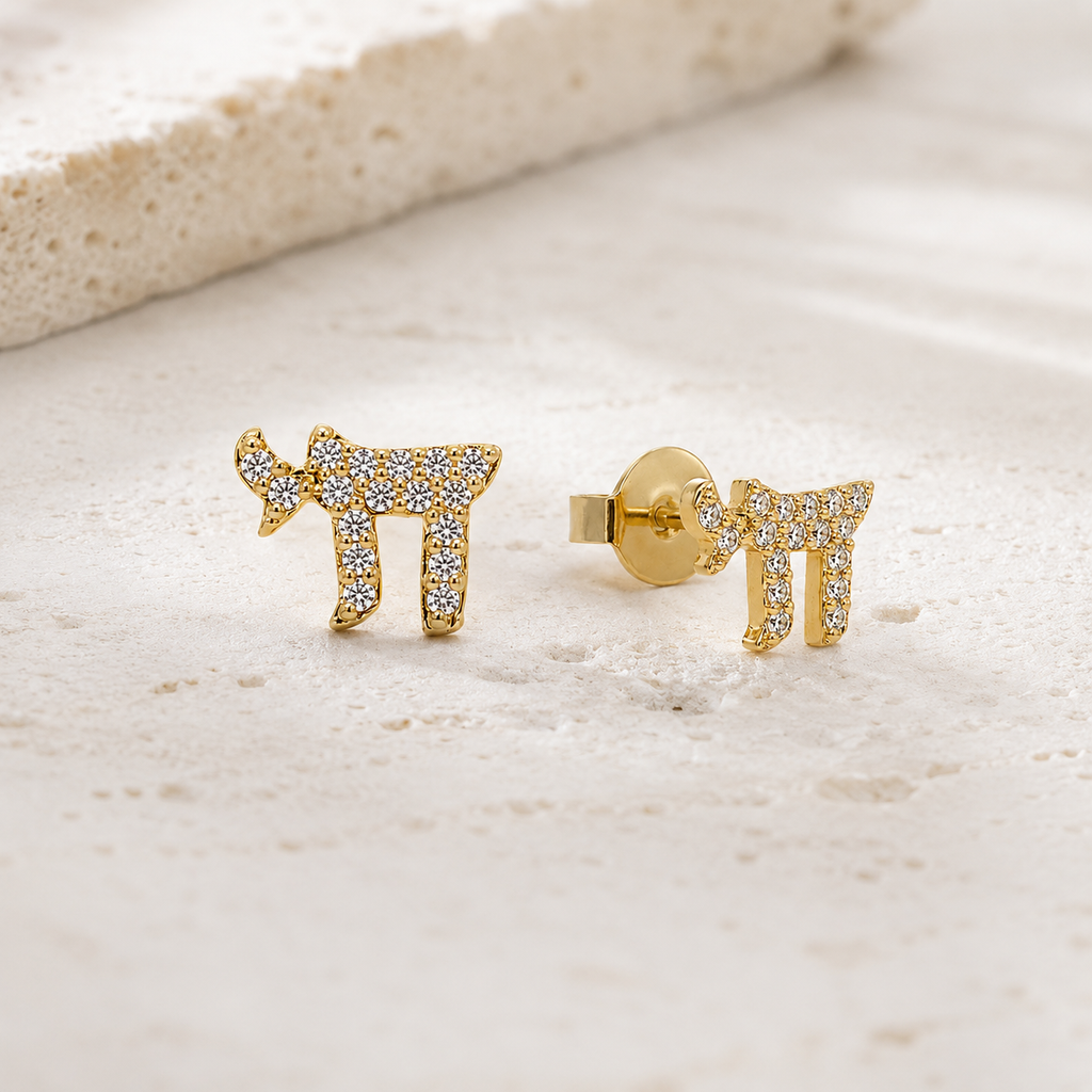 Gold tone Chai Pavé Stud Earrings styled on a neutral stone surface.