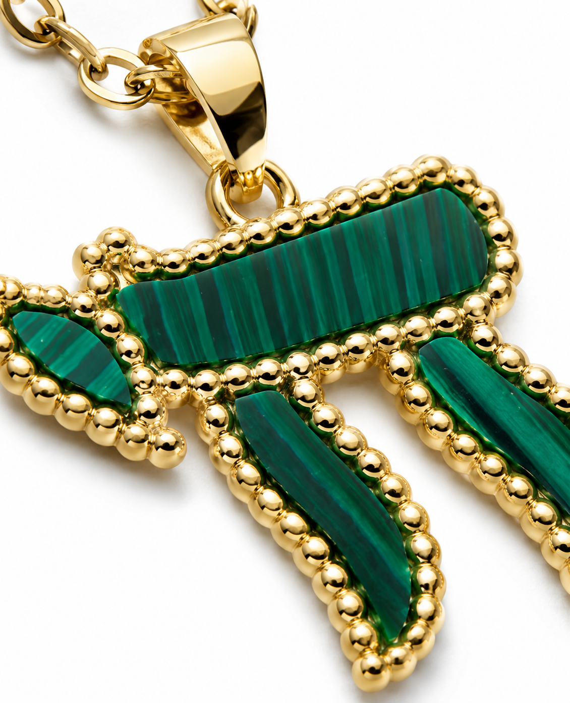 Close-up of the gold tone Chai pendant with green bead-like detailing.