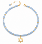 Blue quartz Dead Sea Magen David necklace with gold tone Star of David pendant on a white background.
