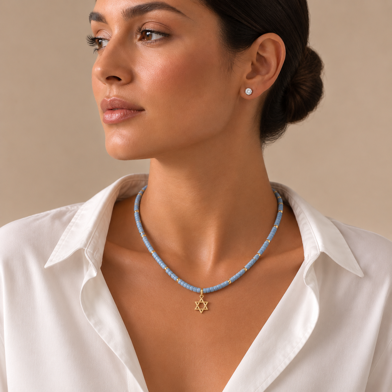 Model wearing the blue quartz Dead Sea Magen David necklace with gold tone pendant.