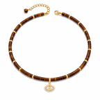 Eden Evil Eye Beaded Choker Necklace with Tiger's Eye gemstone beads and gold tone evil eye charm on a white background.