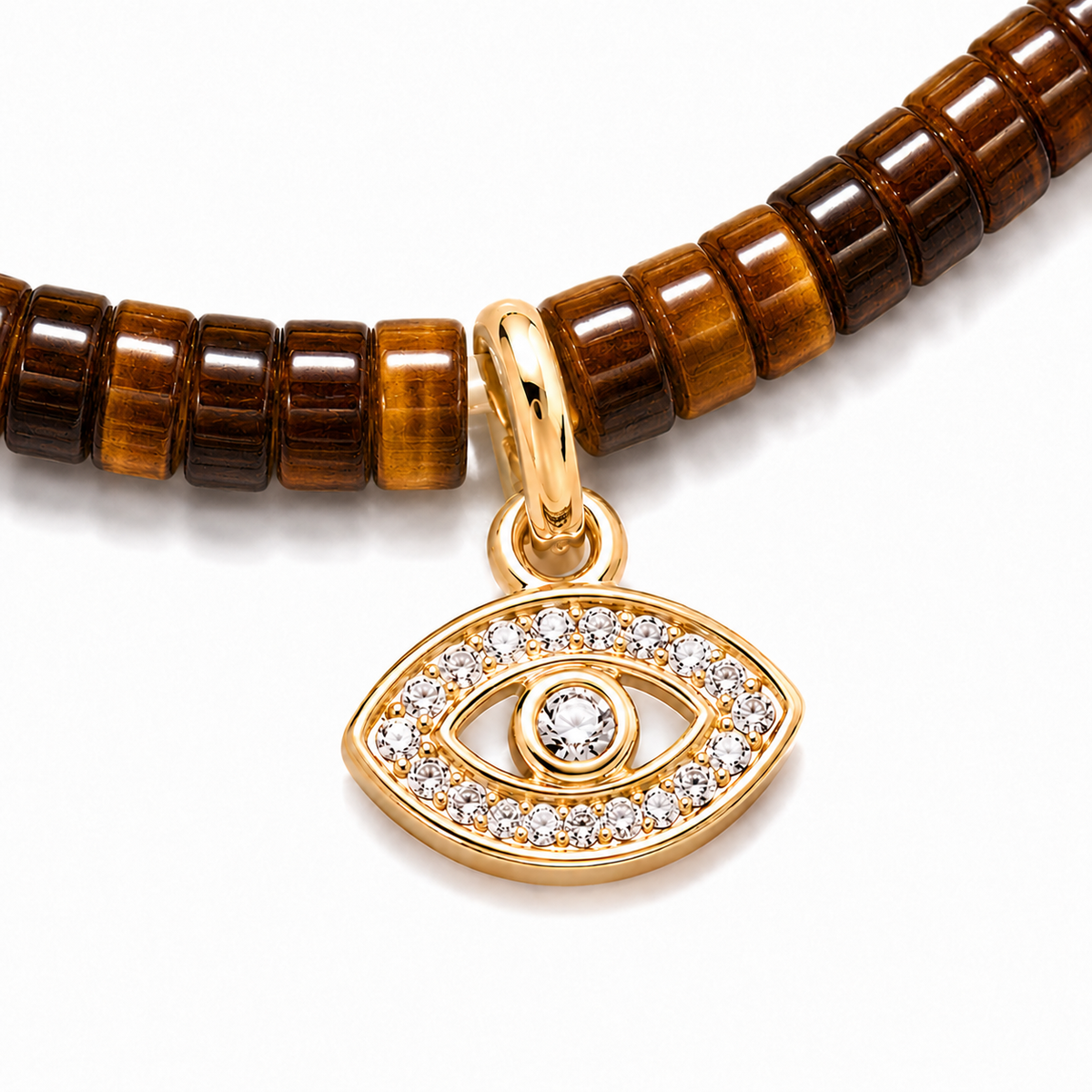 Close-up of the gold tone evil eye charm with pavé cubic zirconia on Tiger's Eye gemstone beads.
