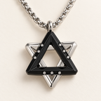 Close-up of the Ezra black Star of David pendant showing layered triangles and cubic zirconia accents.