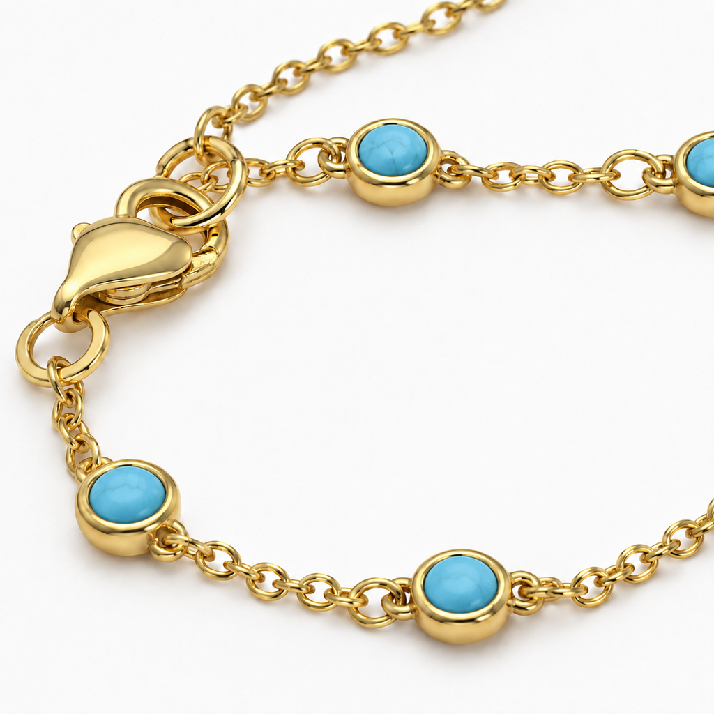 Close-up of the gold tone Hava CZ Hand Chain with bezel-set turquoise-colored cubic zirconia.