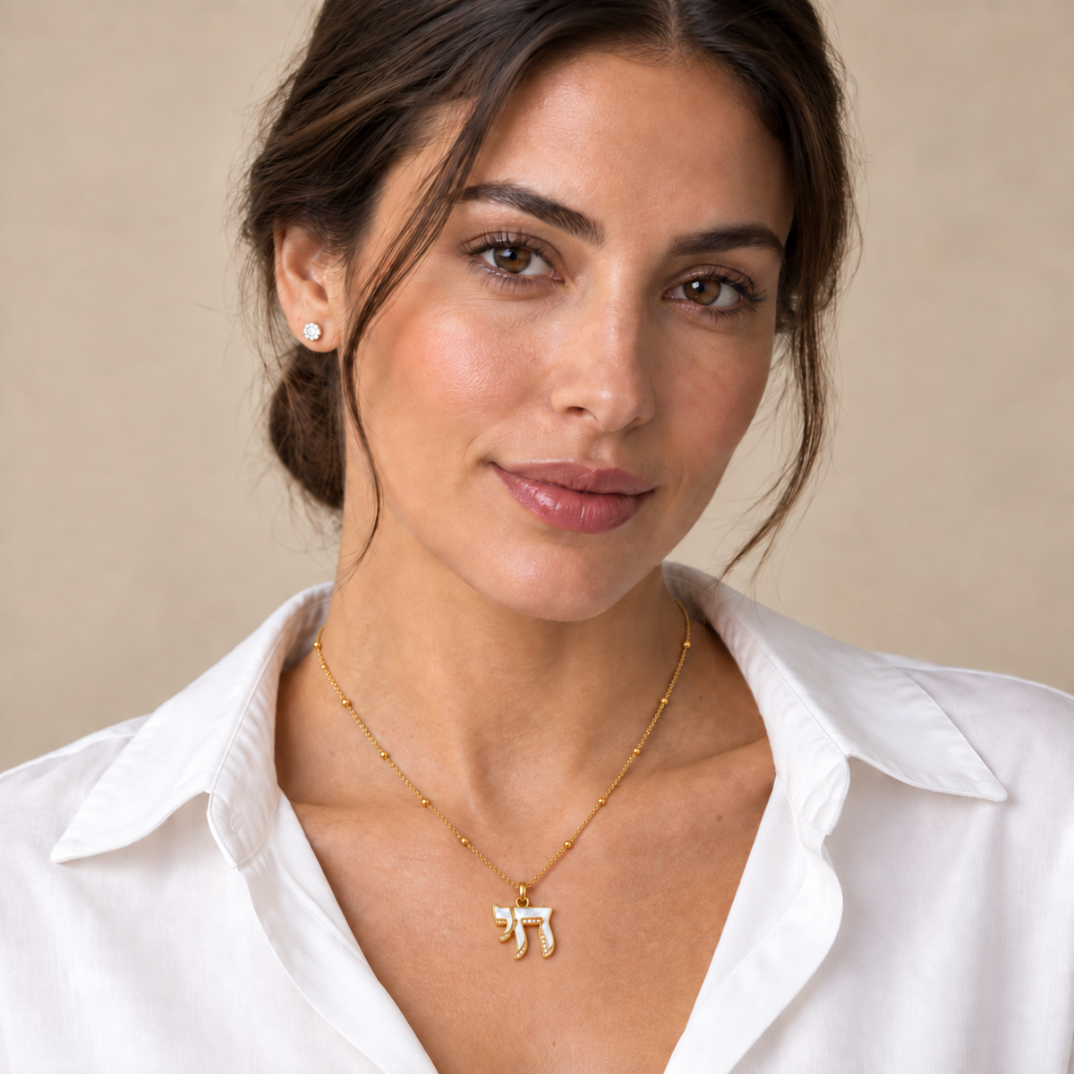 Model wearing Lev Chai Necklace with mother-of-pearl Chai pendant and gold tone chain.