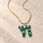 Green Lucky Chai Necklace arranged on pale textured stone in soft natural light.