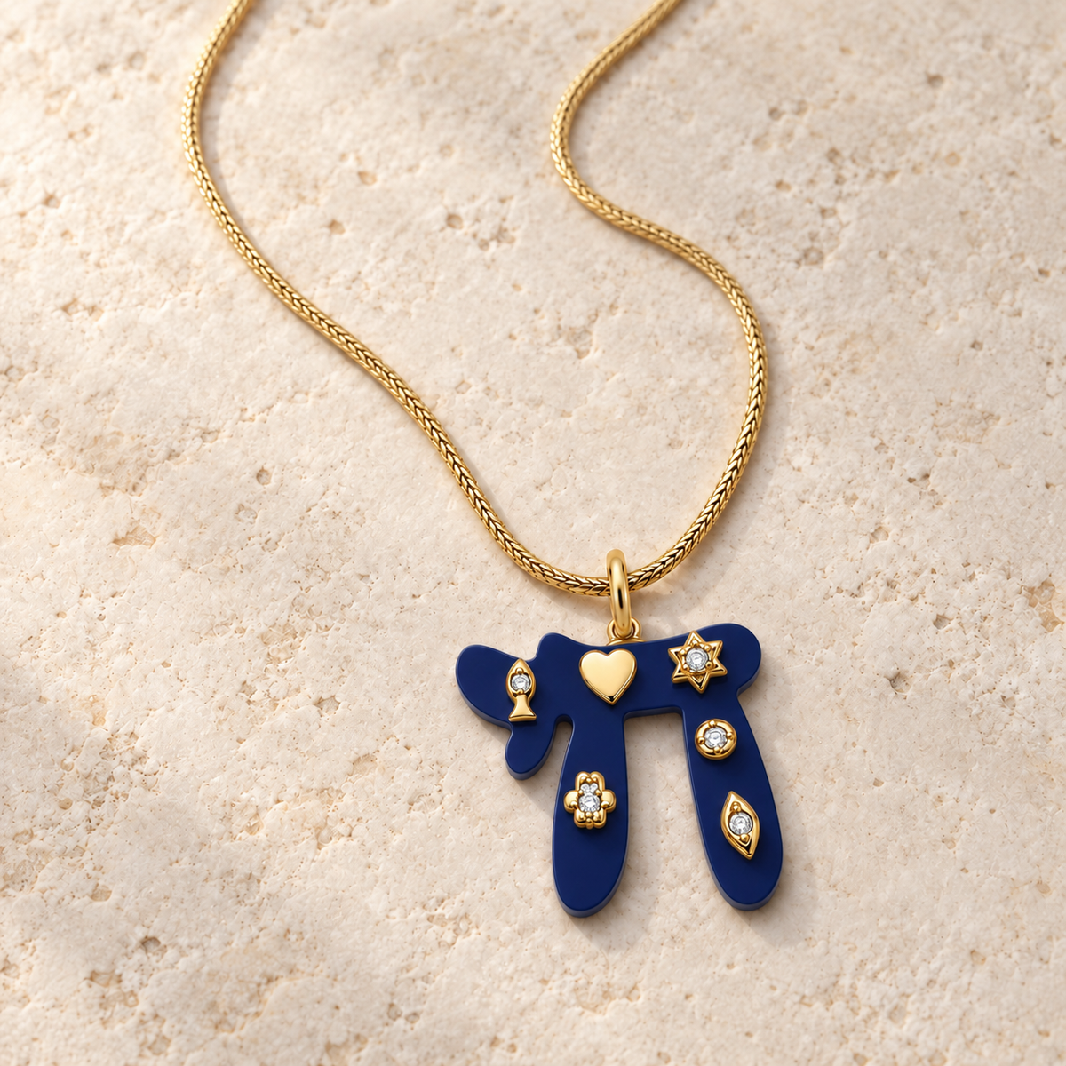 Navy Lucky Chai Necklace arranged on pale textured stone in soft natural light.