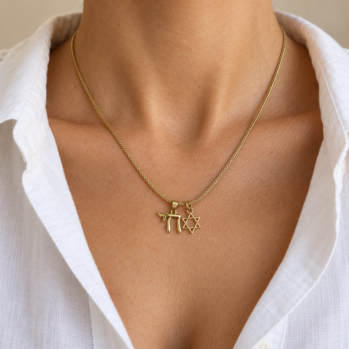Neshama Charm Necklace worn with an open white blouse, cropped below the face.