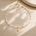 Noa Star of David Beaded Choker Necklace in White Quartz with gold tone details on neutral stone surface.