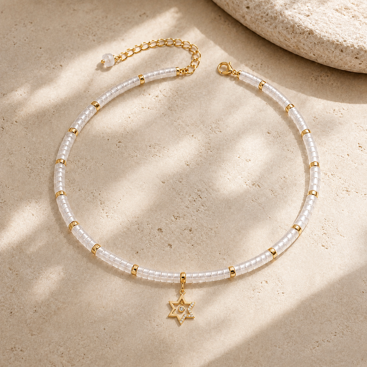 Noa Star of David Beaded Choker Necklace in White Quartz with gold tone details on neutral stone surface.