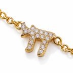 Close-up of the pavé cubic zirconia Chai charm on the Gold Tone Pavé Trio Bracelet.
