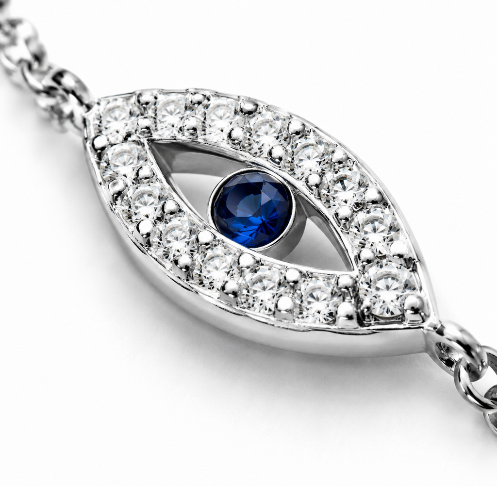 Close-up of the silver tone evil eye charm with a blue center and sparkling stone accents.