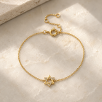 Gold tone Petite Magen David Bracelet styled on a neutral stone surface.