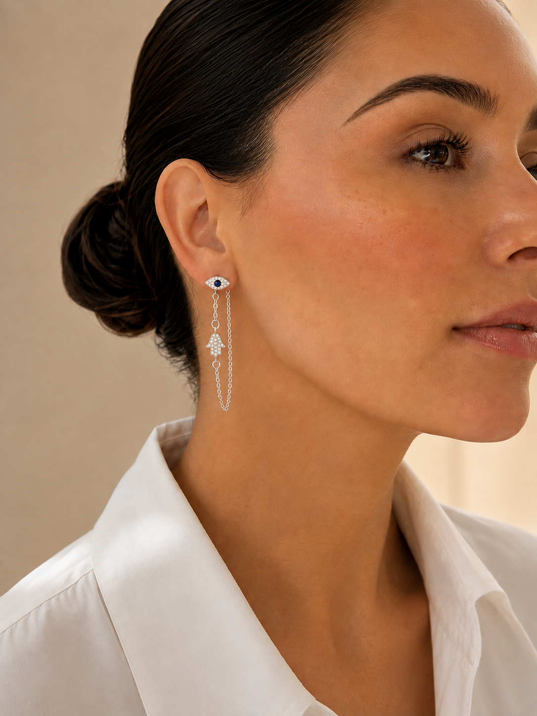 Model wearing the Silver Tone Protection Drop Chain Earrings with pavé Evil Eye studs and Hamsa drop charms.
