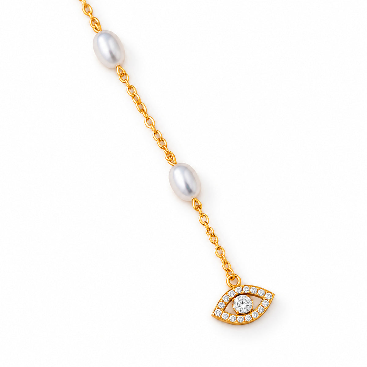 Close-up of pearl beads, a gold tone chain, and the pavé CZ evil eye charm on ivory stone.